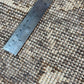 Textured brown and beige carpet with a metal ruler for scale.