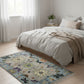 Bedroom with a floral rug on the floor and a bed in the background.