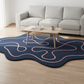 Navy blue rug with pink abstract patterns in a living room setting.