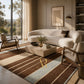 A modern living room scene featuring a large striped area rug in brown, beige, and light blue tones, styled with a curved cream boucle sofa, matching armchairs, and a stone coffee table.