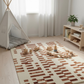 Children's playroom with a patterned rug, teepee, and toys.