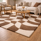 Living room with a patterned brown and beige rug, sofa, and armchair.