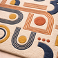 Close-up of a geometric patterned rug with orange, blue, and yellow shapes on a beige background.