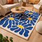Living room with a blue floral rug, coffee table, and furniture.