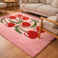 Pink rug with red tulip design in a living room setting