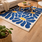 Living room with a blue floral rug on wooden flooring