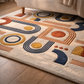 Geometric patterned rug with blue, orange, and yellow shapes on a beige background