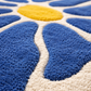 Close-up of a textured rug with blue, yellow, and white pattern