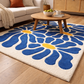 Living room with a blue floral rug, wooden coffee table, and beige sofa.