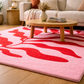 Living room with a pink and red patterned rug, wooden coffee table, and beige sofa.