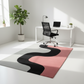 Modern office with a colorful abstract rug, desk, and chair.