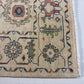 Close-up of a patterned rug with intricate designs on a light background