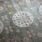 Close-up of a patterned rug with floral designs and a central medallion.