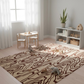 Children's playroom with a patterned rug, wooden furniture, and toys.