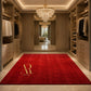 A luxurious red rectangular area rug with a gold monogram logo and the brand name 'Arabella Rug' printed on it, displayed in a spacious, elegantly decorated walk-in closet with wooden cabinets and a crystal chandelier.