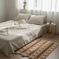 Neatly made bed with white bedding and pillows in a bright bedroom.