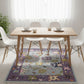 Dining room with a wooden table and chairs on a colorful floral rug.