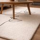 Beige rug with black abstract design in a room with wooden furniture.