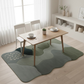 Dining area with a wooden table and chairs on a green patterned rug.