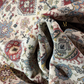 Close-up of patterned fabric with intricate designs and a brand logo.