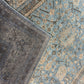 Close-up of two patterned rugs with one being dark gray and the other having a floral design.