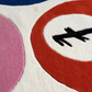 Close-up of a colorful abstract design with red, white, and blue circles on a textured surface.