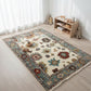 Decorative rug with floral patterns on a wooden floor in a room with toys and a bookshelf.