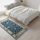 Bedroom with a floral patterned rug on wooden flooring