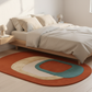 Bedroom with a colorful oval rug on the floor