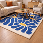 Living room with a blue floral rug, beige sofa, and wooden coffee table.