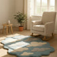 Rug with cloud design in a room with a rocking chair and plant
