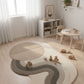 Children's playroom with a round rug, toys, and furniture.