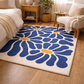 Blue floral rug on a wooden floor with a cozy living room setting.