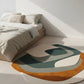 Modern bedroom with a geometric patterned rug on a light wooden floor.