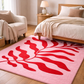 Pink rug with red leaf design in a bedroom setting