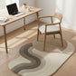 Modern home office with a desk, chair, and decorative rug on a wooden floor.
