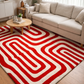 Living room with a red and white patterned rug, beige sofa, and wooden coffee table.