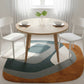Dining room with a round wooden table and chairs on a colorful area rug.