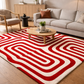 Living room with a red and white patterned rug, beige sofa, and wooden coffee table.