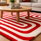 Red and white striped rug in a living room with a wooden coffee table.
