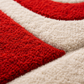 Close-up of a red and beige geometric patterned rug.