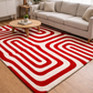 Living room with a red and white patterned rug, beige sofa, and wooden coffee table.
