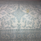 Patterned rug with intricate designs in shades of blue and gray.