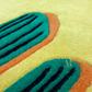 Close-up of a textured surface with green, orange, and black patterns on a yellow background.