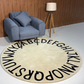 Beige patterned Alphabetical rug on a floor with sofa and side lamp