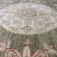Close-up of a textured fabric with floral patterns in beige and green.