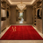 A luxurious red rectangular area rug with a gold monogram logo and the text 'Artemis Royal' printed on the front, displayed in a spacious, elegantly decorated walk-in closet with wooden cabinets and a crystal chandelier.