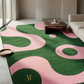 Living room with a green and pink patterned rug, coffee table, and sofa.