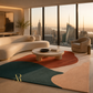 A modern living room with a large abstract area rug in teal, rust, cream, and blush tones, styled with a curved cream sofa, round coffee table, and a beige armchair, set against floor-to-ceiling windows overlooking a city skyline at sunset.