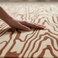 Hand touching a textured surface with wavy patterns